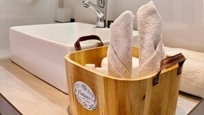 A bathroom with a wooden towel holder, a white sink, and a mirror above it. - Clear point studio  (Dikwella)