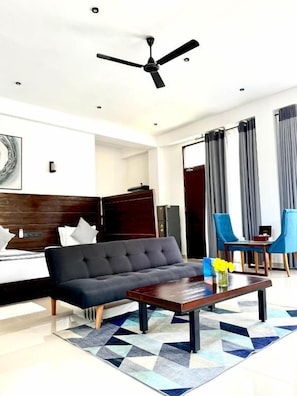 A modern living room with a sofa, coffee table, and blue chairs.