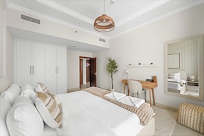A bedroom with a large bed, a desk, a chair, a mirror, and a potted plant. - Vogue | Reflection near Reem Central Park & Beach (Abu Dhabi)
