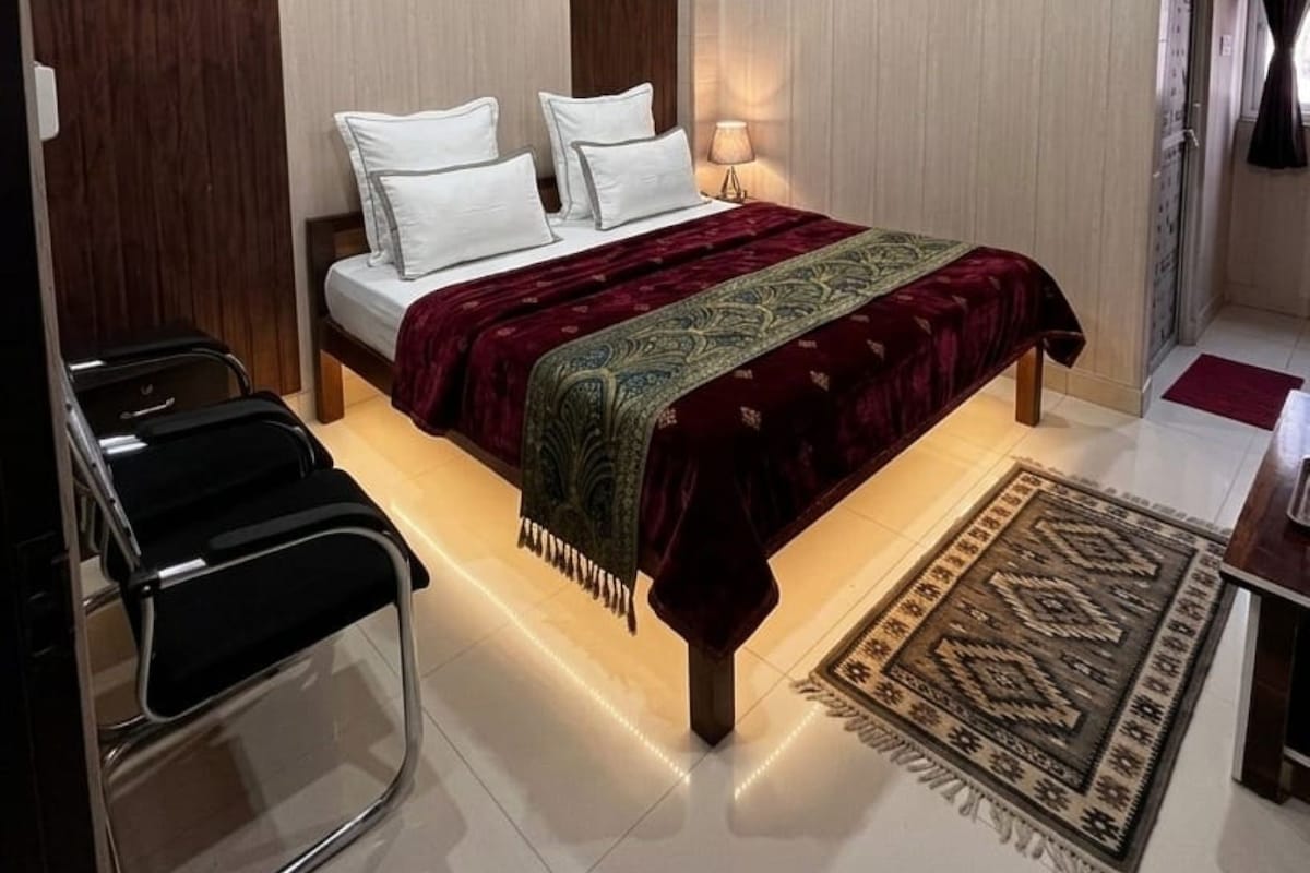 Ein Schlafzimmer mit einem Bett, einem Nachttisch, einer Lampe und einem Deckenventilator.