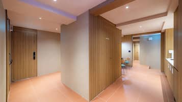 A modern hallway with wooden paneling, a staff-only sign, and a seating area with chairs.
