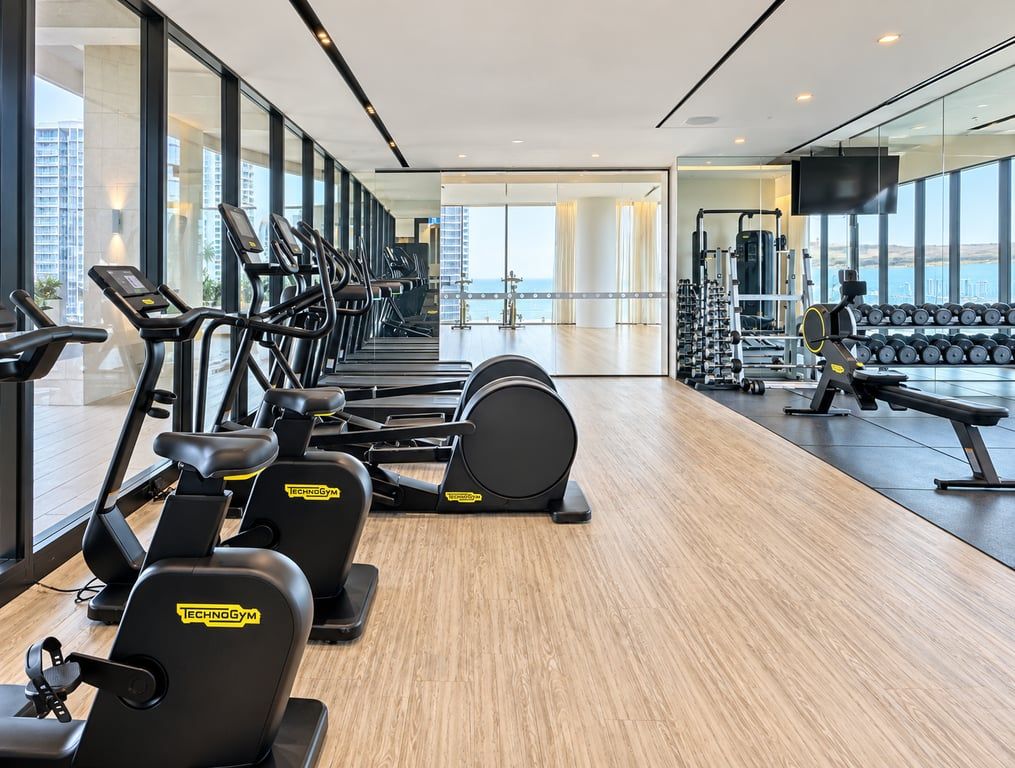 A gym with treadmills, elliptical machines, and weightlifting equipment.