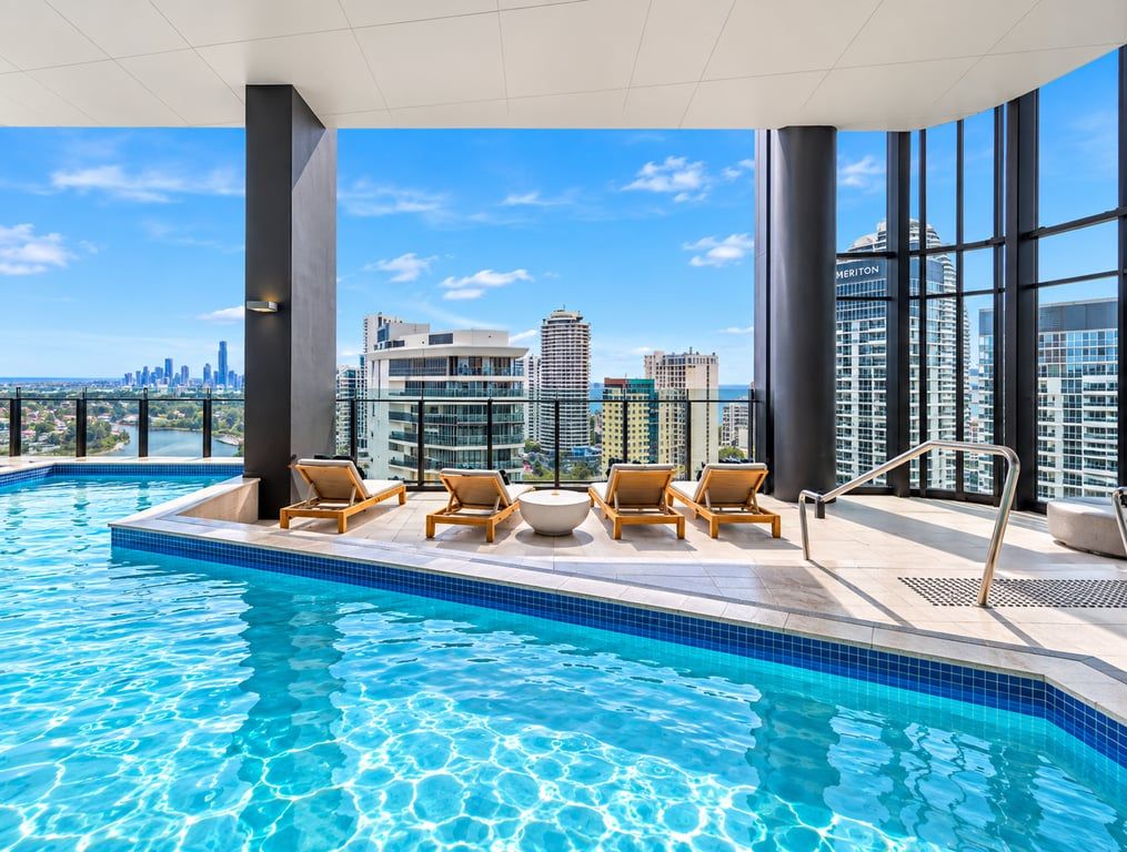 Ein Dachpool mit Infinity-Kante, Liegestühlen, Blick auf die Stadtlandschaft und moderner Architektur.