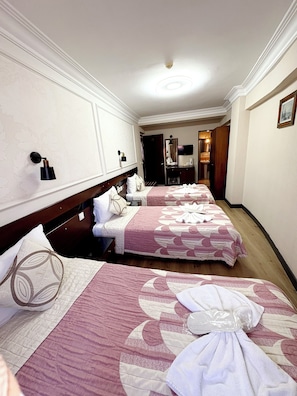 Une chambre d’hôtel avec deux lits, un bureau, un miroir et une armoire.