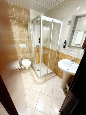 Une salle de bain moderne avec une douche à parois de verre, des toilettes et un lavabo.