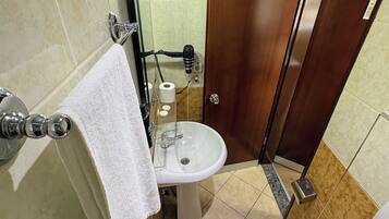 A bathroom with a shower, sink, and toilet.