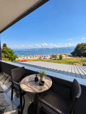 A terrace with a table and chairs overlooking a beach. - Efege Suit (Fatsa)