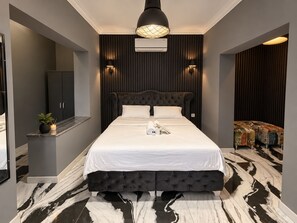 A modern bedroom with a tufted headboard, a marble floor, and a built-in air conditioning unit. - Efege Suit (Fatsa)