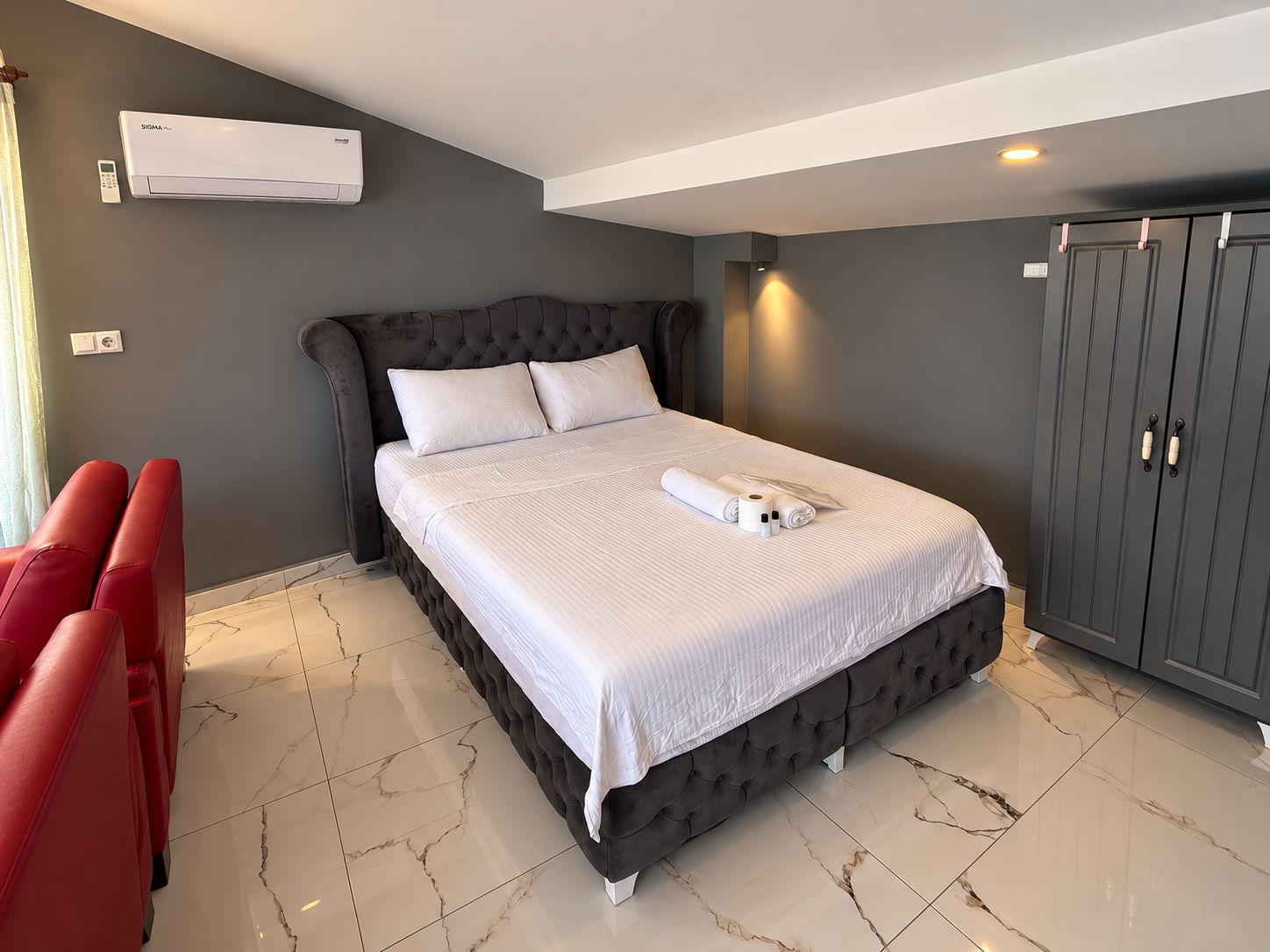 Habitación de hotel con cama, armario y zona de estar.