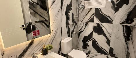 A bathroom with a white sink, toilet, and shower.
