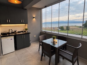 A modern kitchen with a view of a beach and mountains.