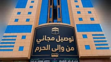 A hotel with a prominent entrance and signage in Arabic.