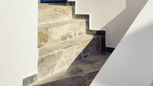 A staircase with a blue door leading to a room. - Arie Waterfront House - A Few Steps to the Sea (milatos beach)
