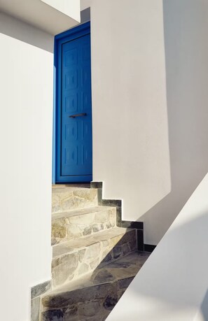 Un escalier avec une porte bleue qui mène à une pièce.