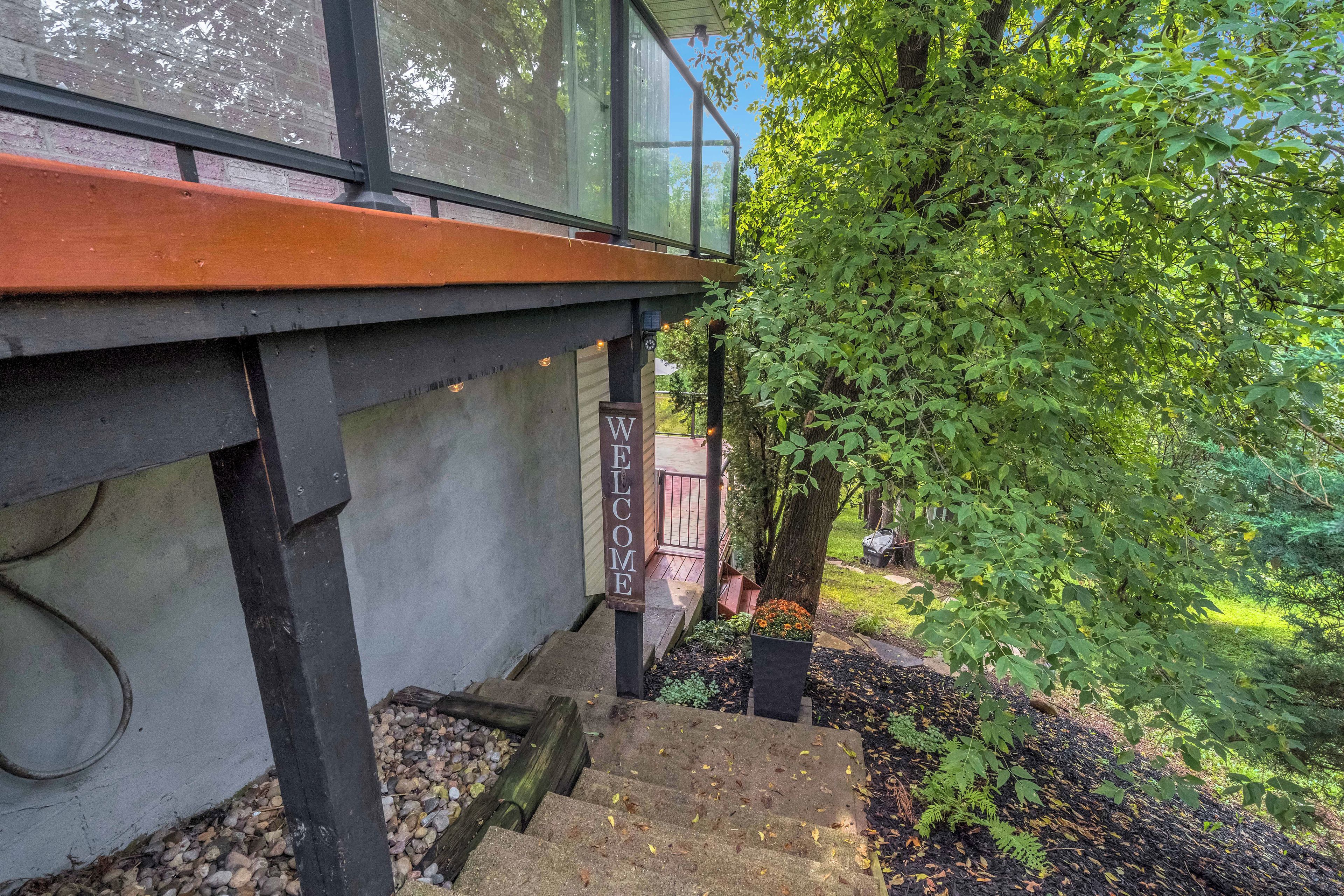 A modern building with a glass facade, a wooden deck, and a sign that reads 'WELCOME'.