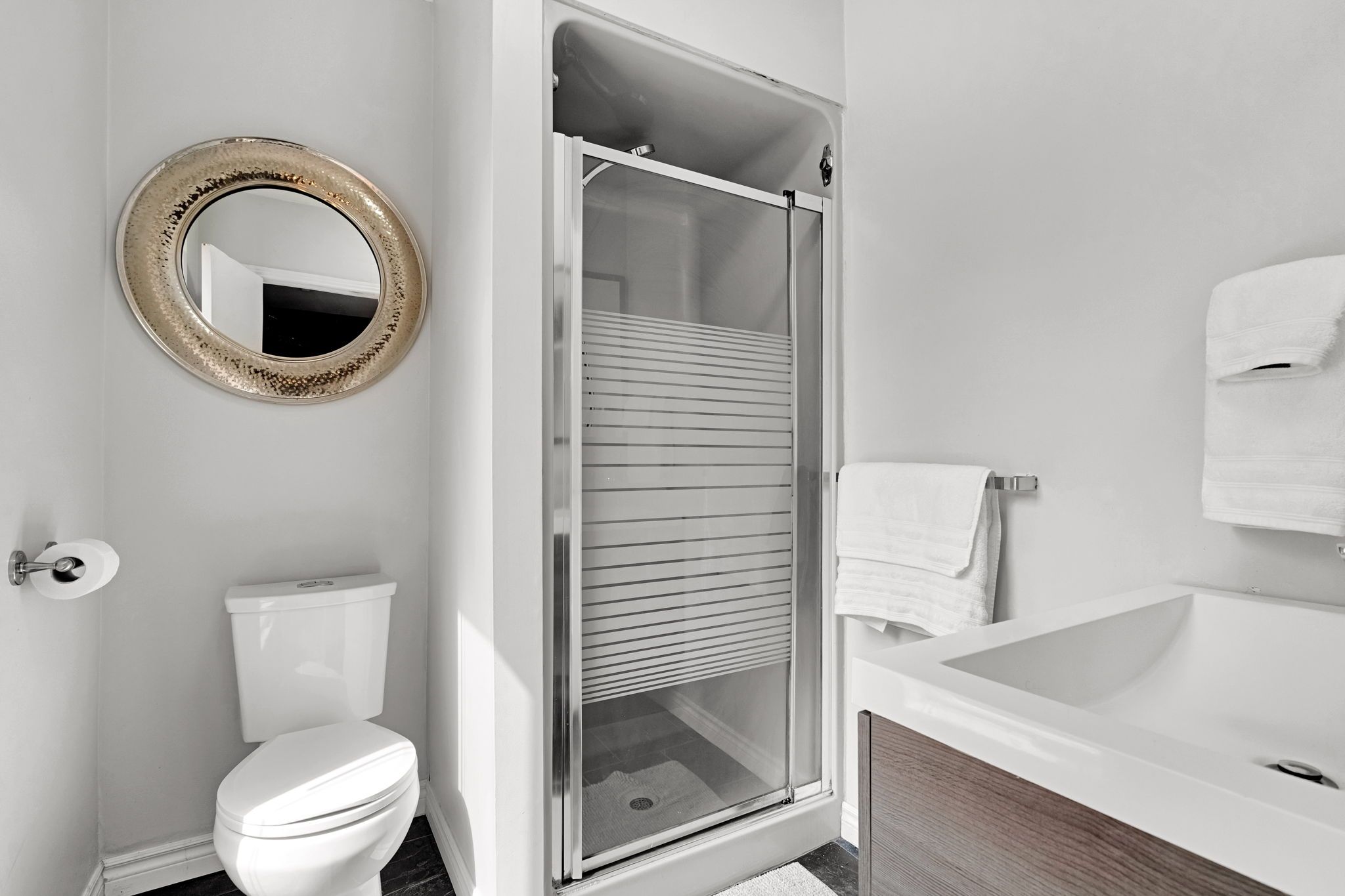 Ein Badezimmer mit Toilette, Duschkabine, Badewanne und Spiegel.
