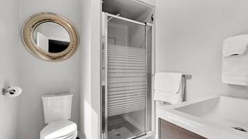 Ein Badezimmer mit Toilette, Duschkabine, Badewanne und Spiegel.