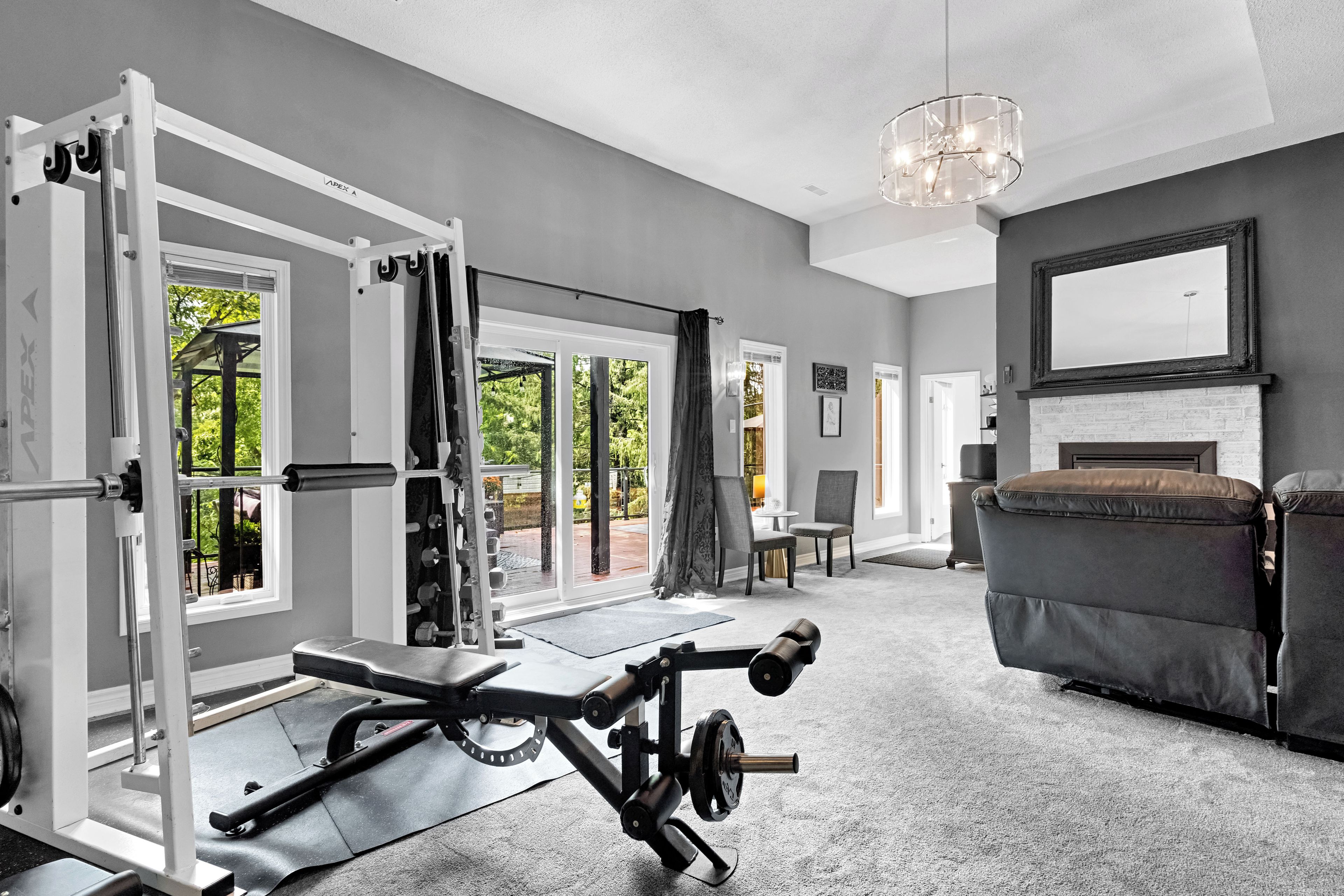 A home gym with a pull-up bar, bench press, and weight rack.