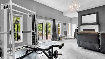 A home gym with a pull-up bar, bench press, and weight rack.