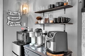 A kitchen with a coffee machine, a microwave, and a coffee grinder on the counter.