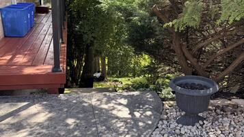 A patio area with a concrete floor, a black outdoor heater, and a pile of white pebbles.