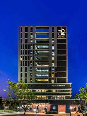 A multi-story hotel building with a prominent logo on the facade.