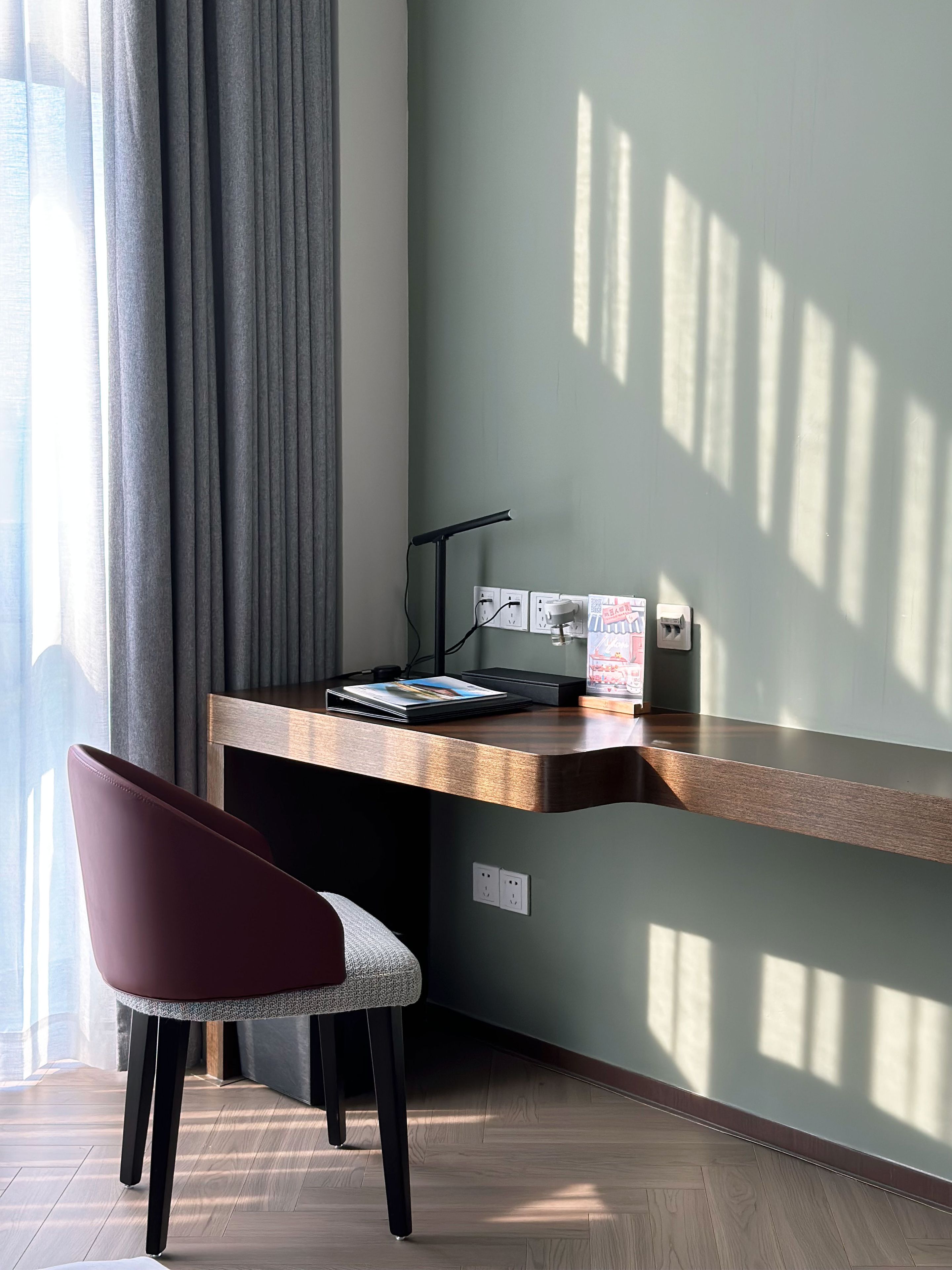 Un espacio de trabajo moderno con un escritorio de madera, una silla y una lámpara.