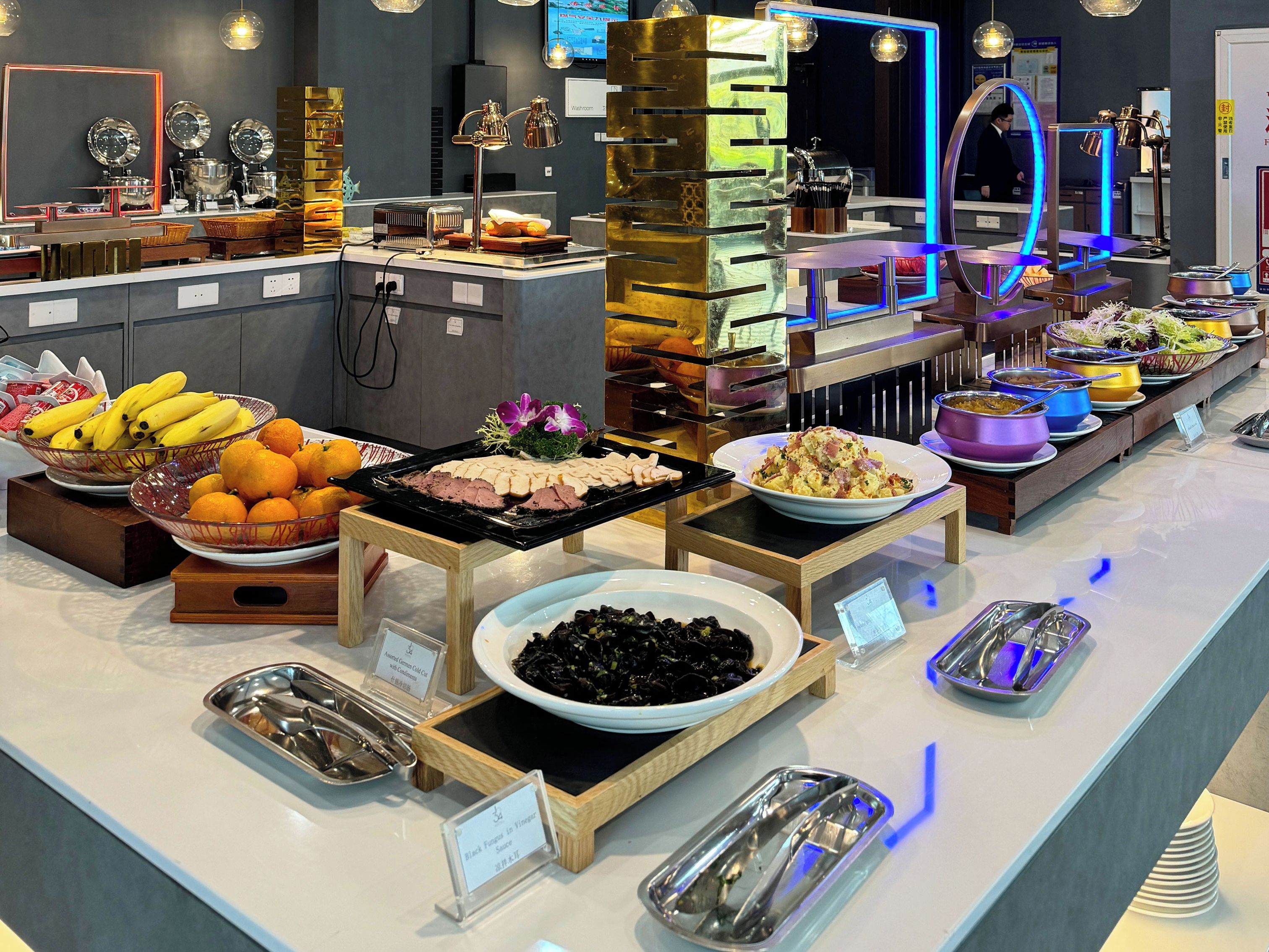 A buffet with various food items and utensils.