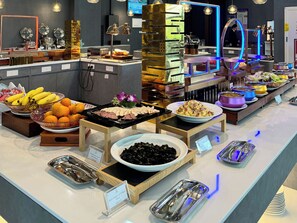 Un bufé con diversos alimentos y utensilios.