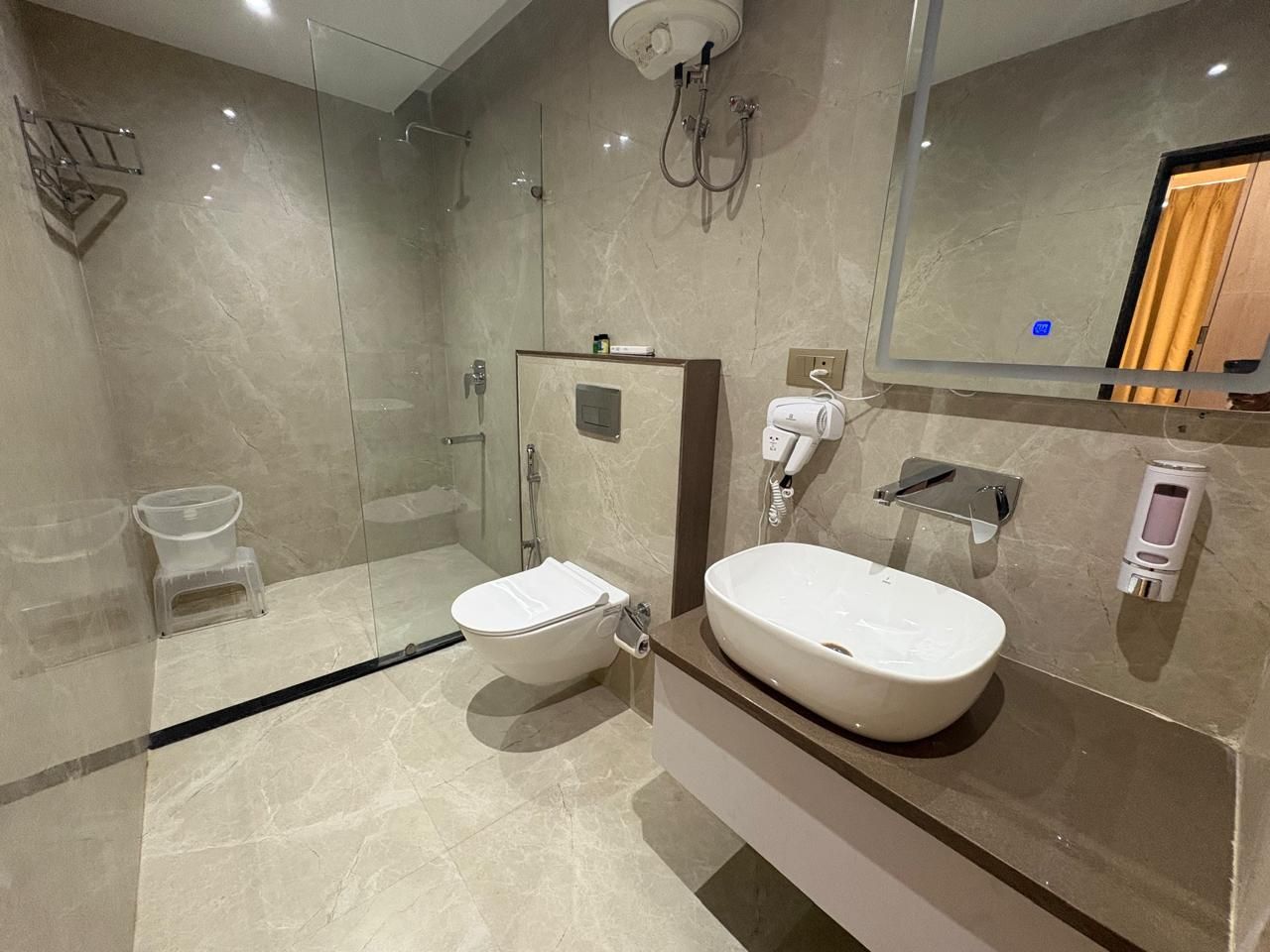 Une salle de bain moderne dotée d’une douche à parois de verre, de toilettes et d’un meuble-lavabo avec un évier.