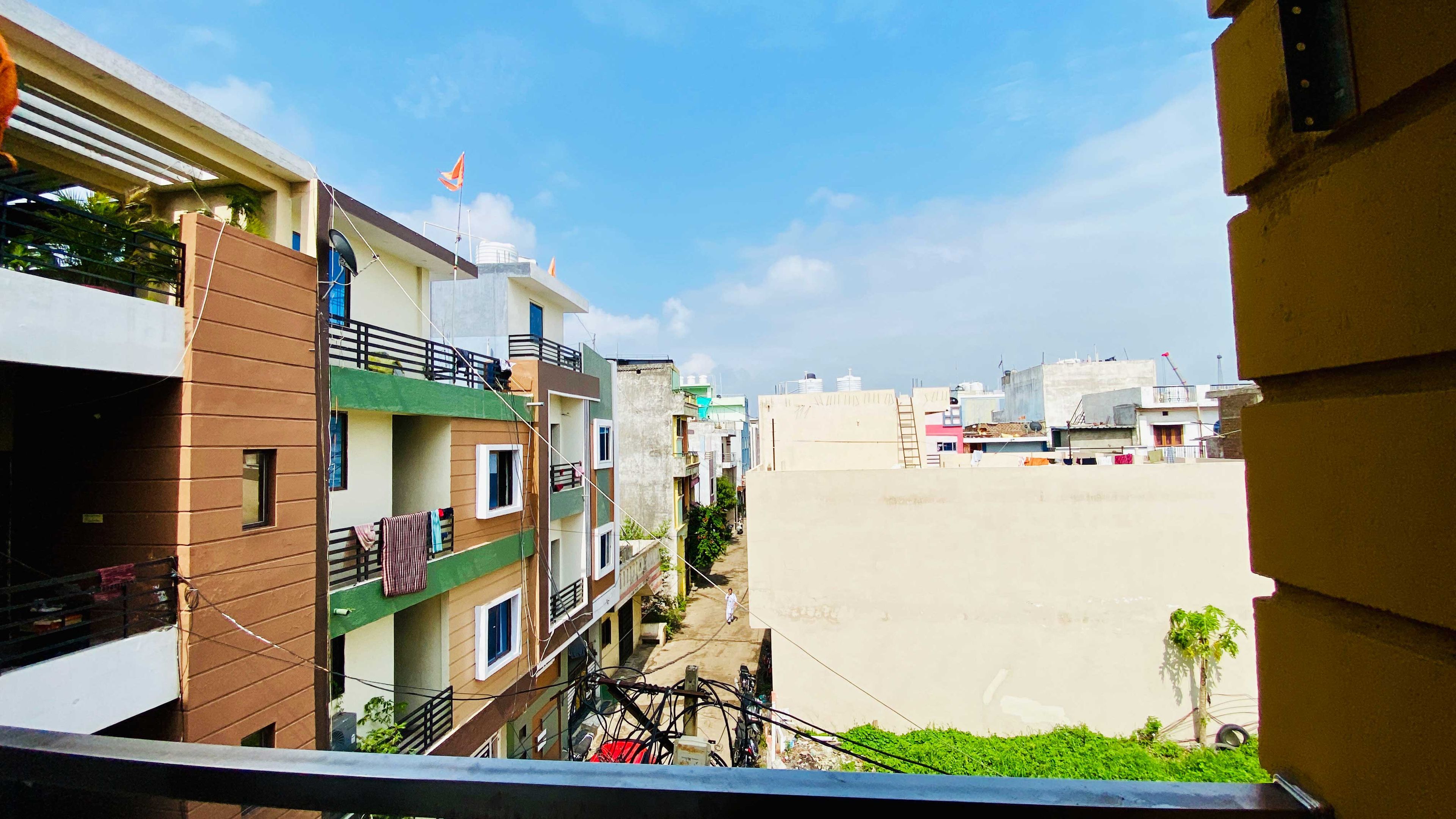 Zona residencial con edificios de varios pisos, balcones y cielo despejado.