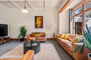 Ein modernes Wohnzimmer mit einer Couch, einem Couchtisch und einem Fernseher.