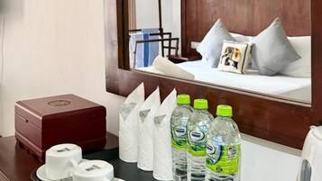 A hotel room with a bed, a tray with toiletries, and a mirror reflecting the room.