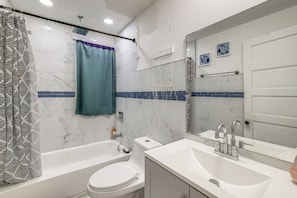 A bathroom with a bathtub, toilet, and sink. - 2 Mi to State Park! Cozy Apt Near Niagara Falls (Niagara Falls)