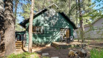 Eine Holzhütte mit Veranda, Fenster und Tür.