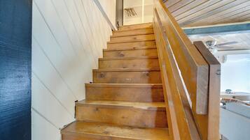 Eine Holztreppe mit Handlauf, der zu einer Zwischenplattform führt.