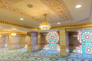 A spacious interior with ornate ceiling patterns, large stained glass windows, and a patterned floor. - Zad Al Hayat Hotel (Makkah)