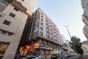 Un hôtel à plusieurs étages, avec une enseigne bien visible portant le nom « ZADA AL HAYA » et un restaurant situé au rez-de-chaussée, facilement identifiable.
