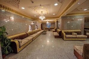 A spacious lobby with a long sofa, a smaller sofa, and a chandelier. - Zad Al Hayat Hotel (Makkah)