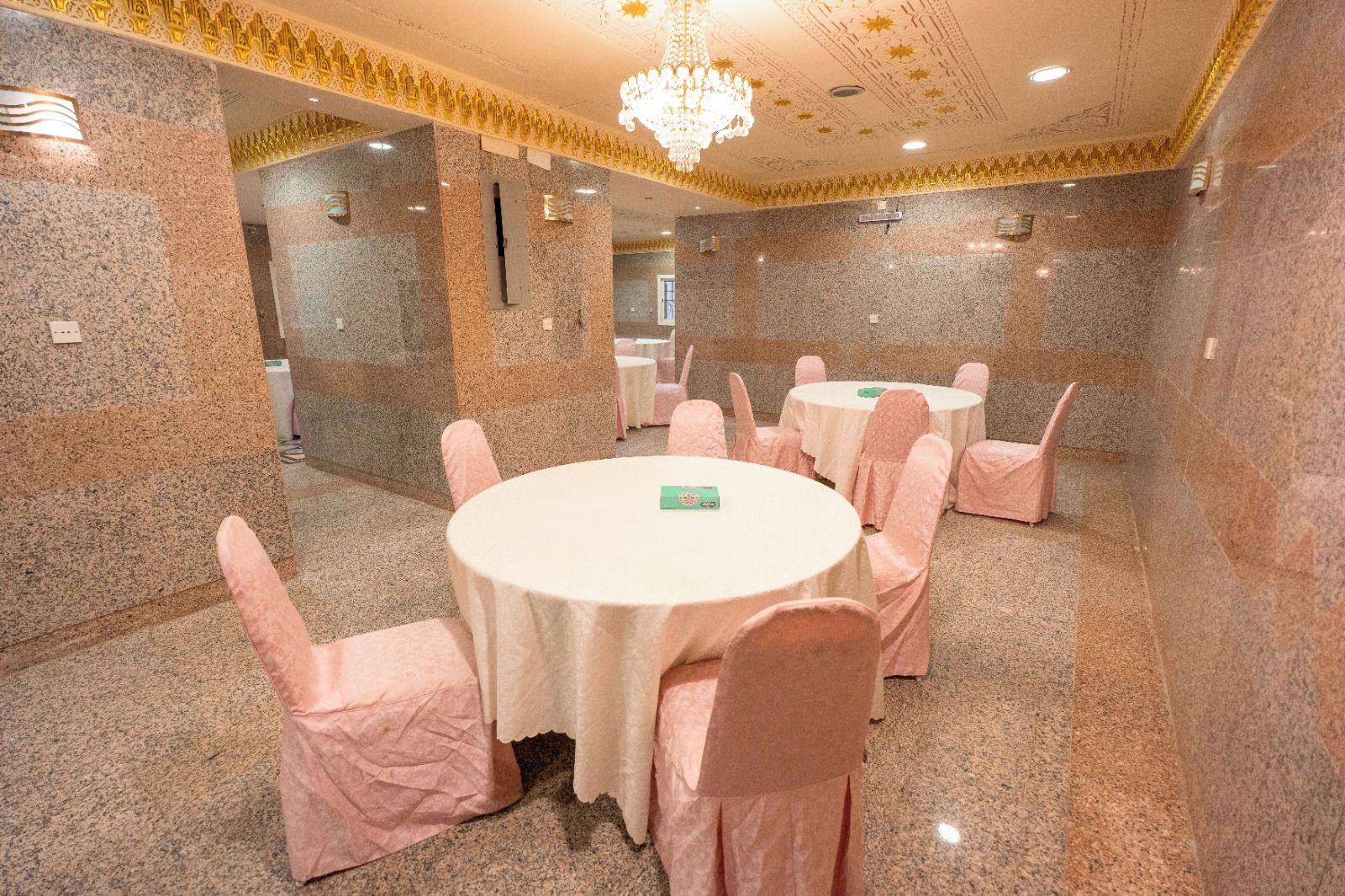 A conference room with round tables, chairs, and a chandelier.