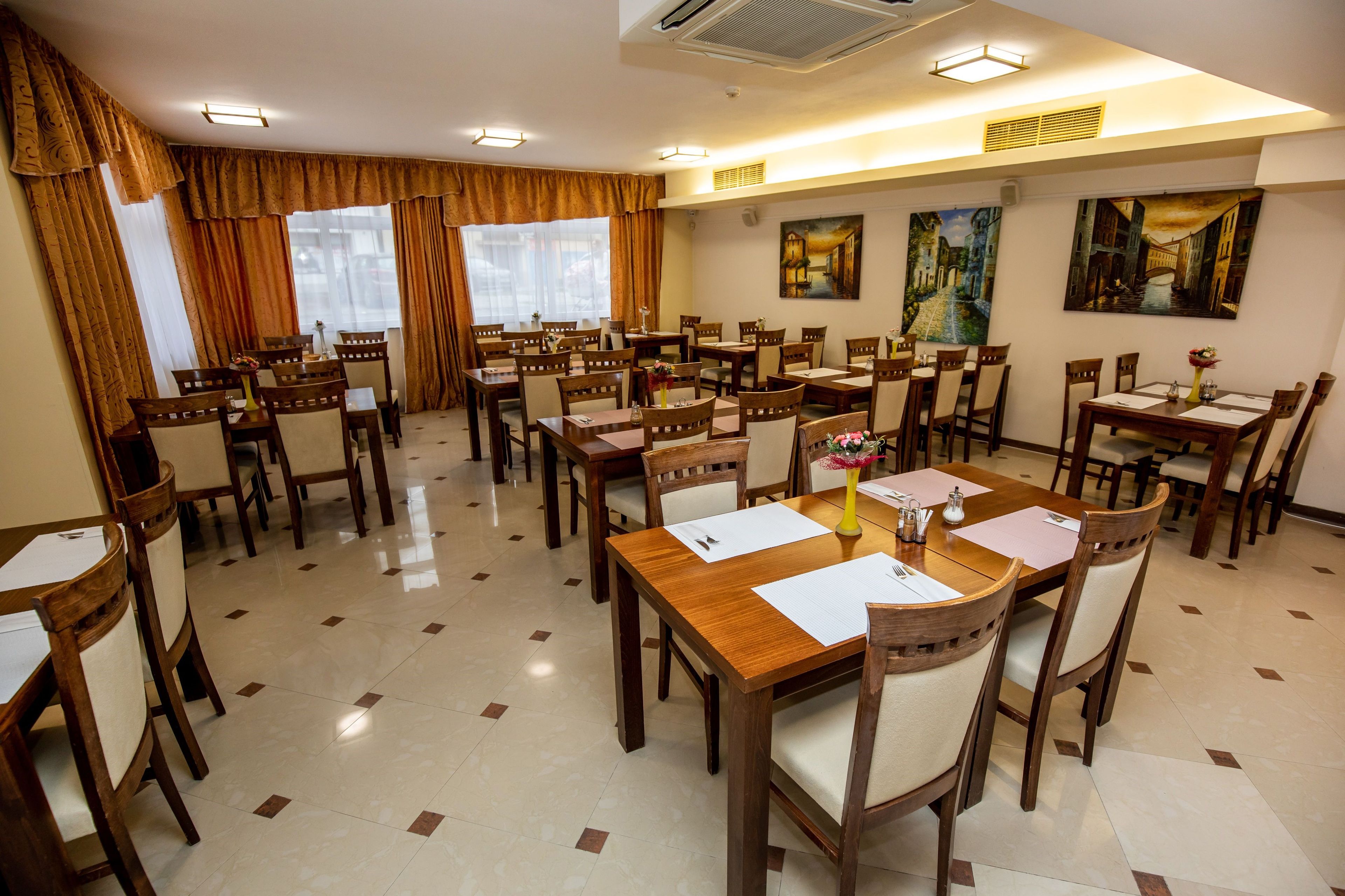 A conference room with multiple tables and chairs, arranged for meetings.