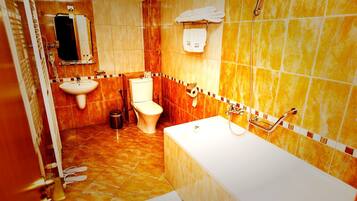 A bathroom with a bathtub, toilet, sink, and a mirror.