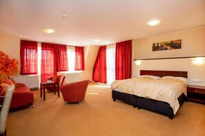 Una habitación de hotel con cama, escritorio, silla y radiador.