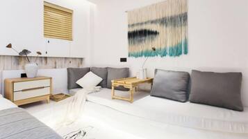 A modern living room with a white sofa, a wooden side table, and a wall-mounted tapestry.