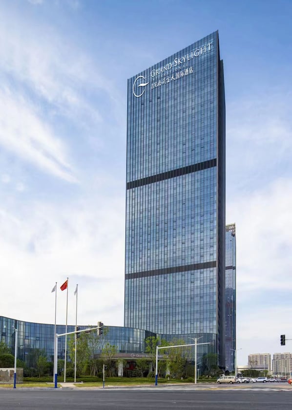A modern skyscraper with a glass facade and the name 'Grand Skylight International Hotel' prominently displayed.