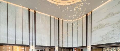 A spacious lobby with a central fountain, high ceilings, and a modern design.