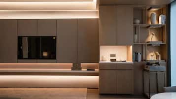 A modern kitchen with built-in appliances, a central island, and a dining area with a round table.