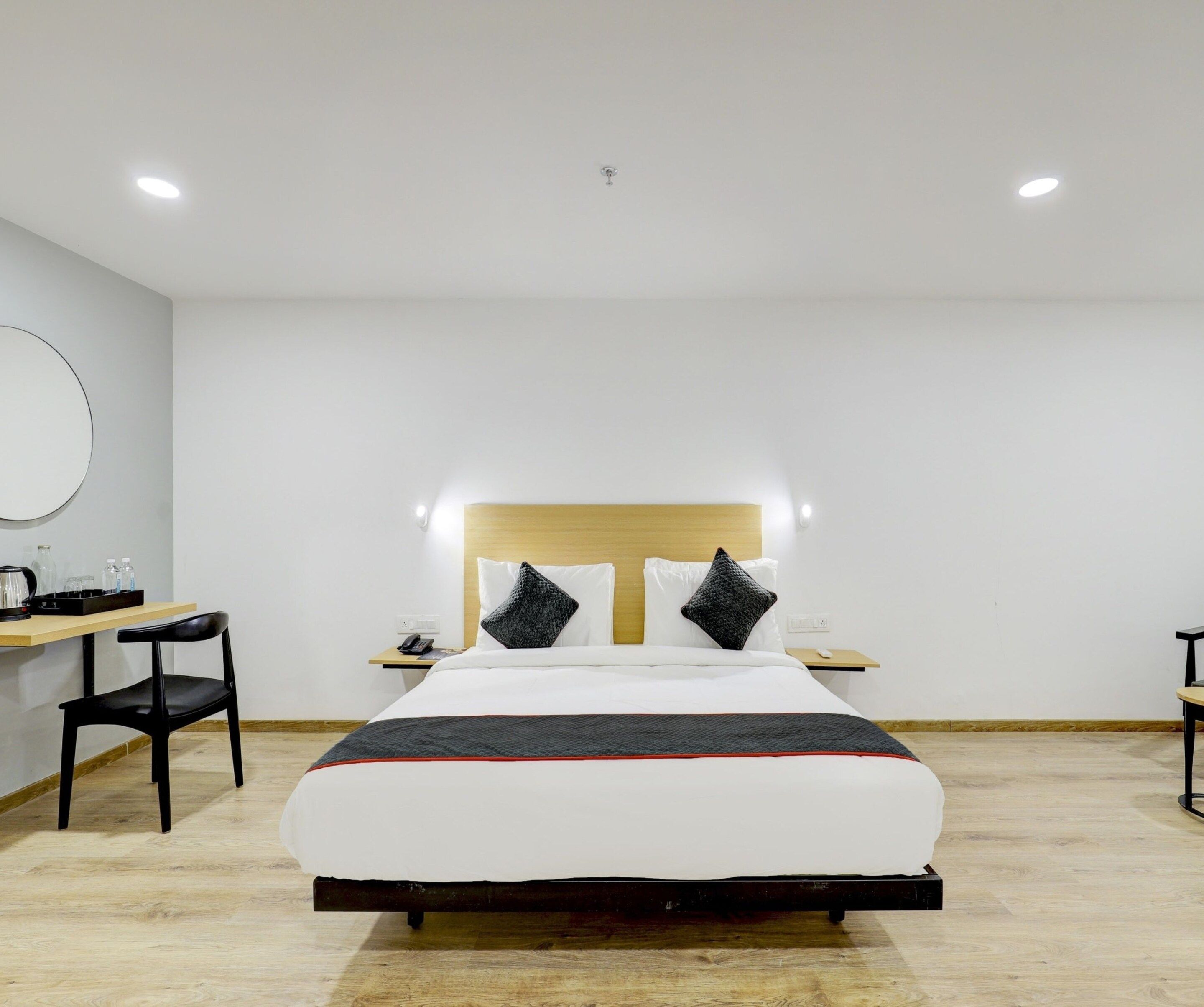 Ein Hotelzimmer mit Bett, Nachttischen, Schreibtisch und Stuhl.