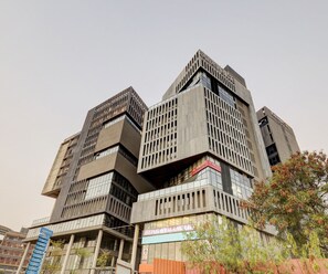 Un immeuble à plusieurs étages doté d’une architecture angulaire originale, avec une enseigne bien visible indiquant la présence d’une salle de sport.