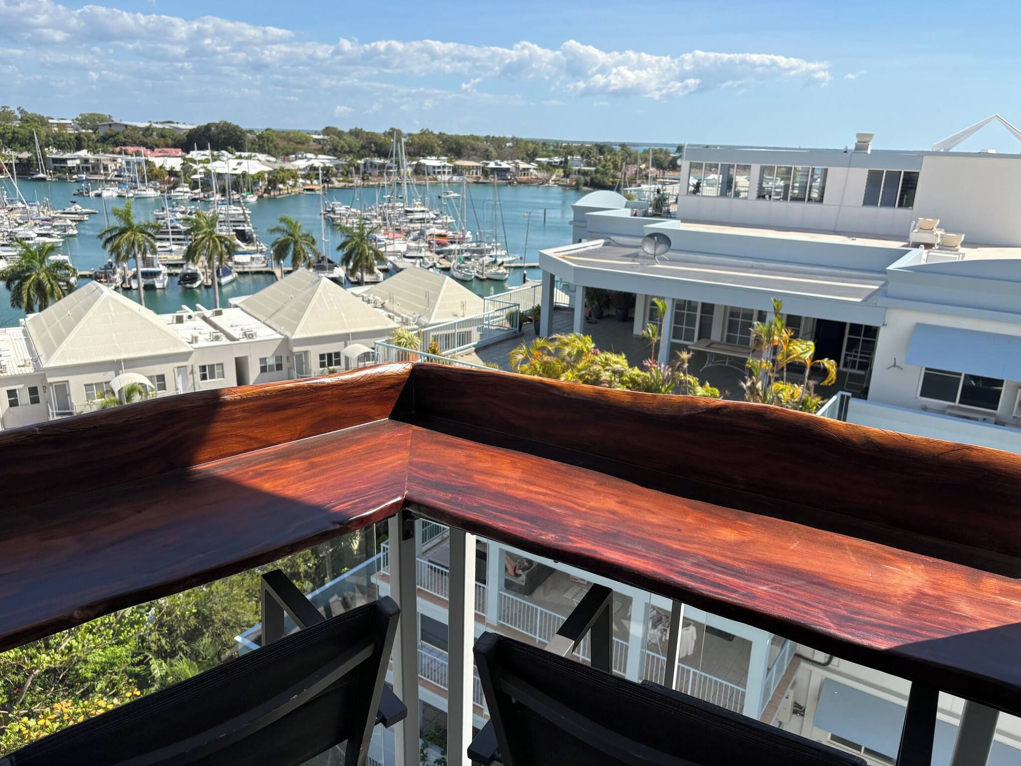 A balcony with a view of a marina, buildings, and a clear sky.